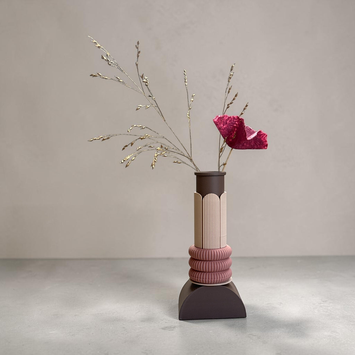 ModuForm ModuVase Emma in bruin en roze met gestructureerde details en gedroogde bloemen op een grijze ondergrond